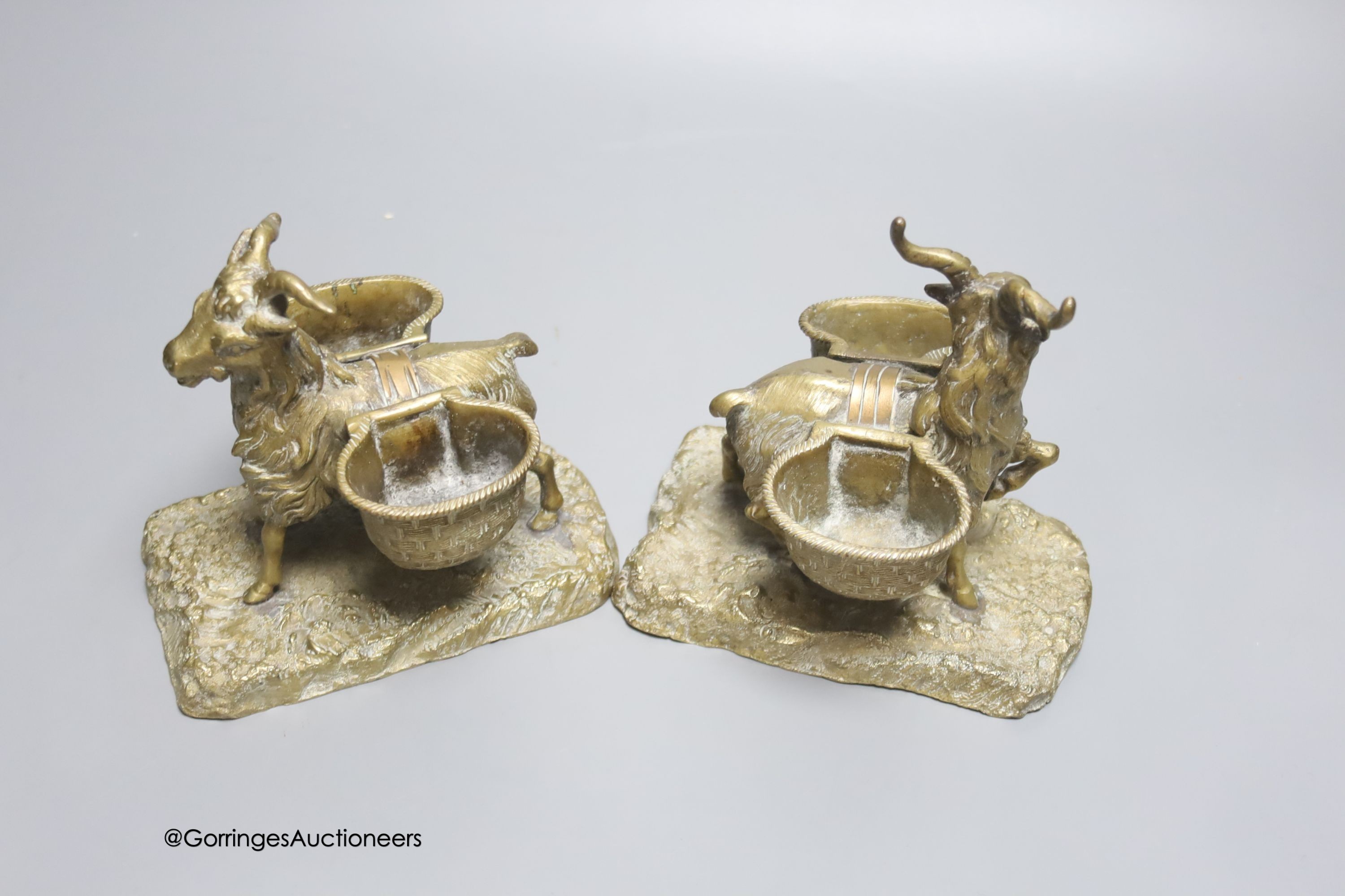 A pair of cast bronze goat salts, tallest 13cm